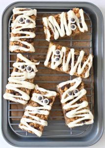 5 simple ingredients make for an easy Granola Bar Mummies snack! Just drizzle some dairy free white chocolate over them and slap some homemade googly eyes on. Spooky goodness!