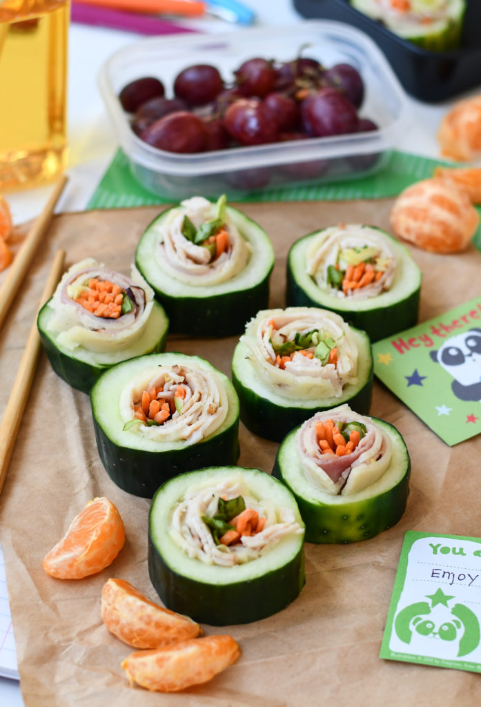 7 Cucumber Sushi rolls on top of a brown paper bag for a fun lunchbox theme.
