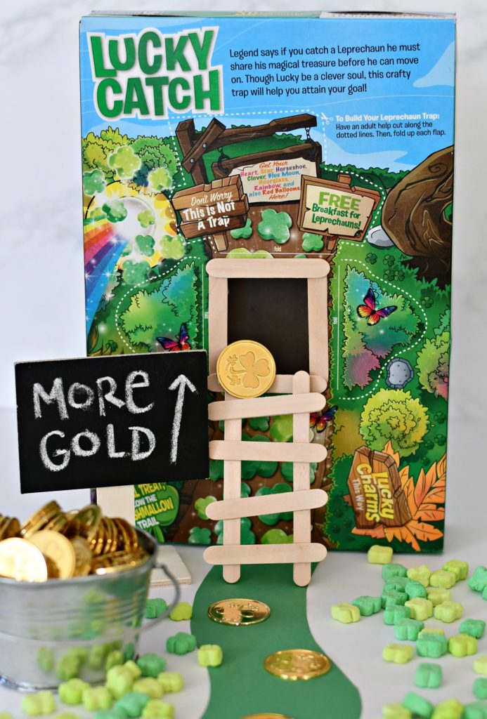 A DIY leprechaun trap made from a cereal box with a popsicle stick ladder